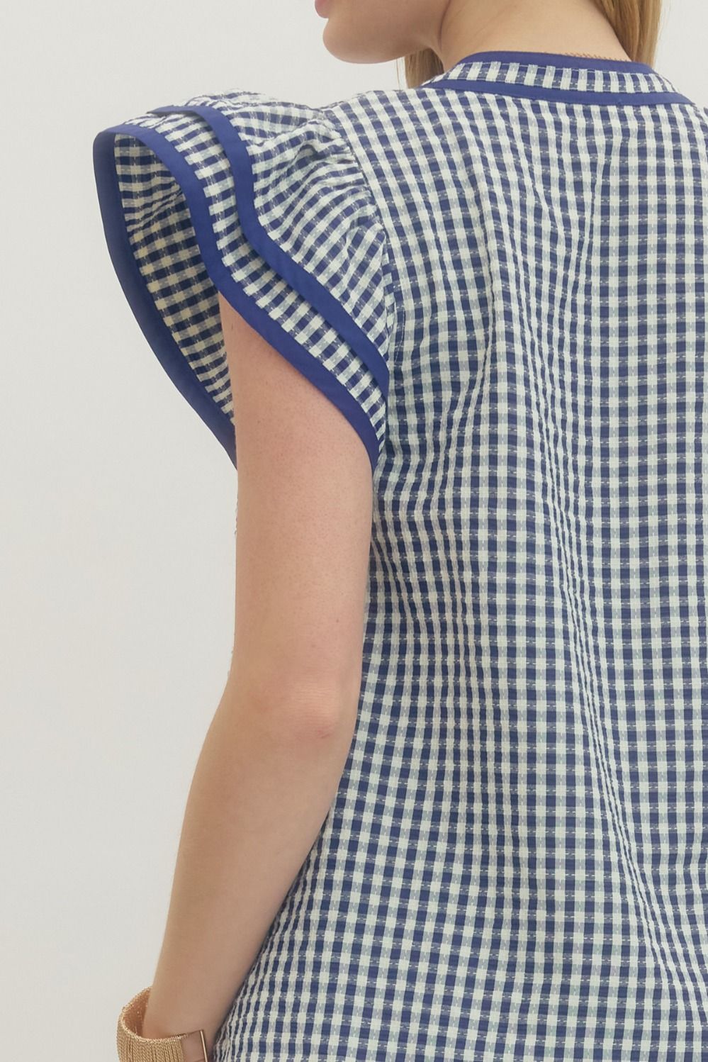 Blue and white checkered dress with ruffled sleeves on a plain background