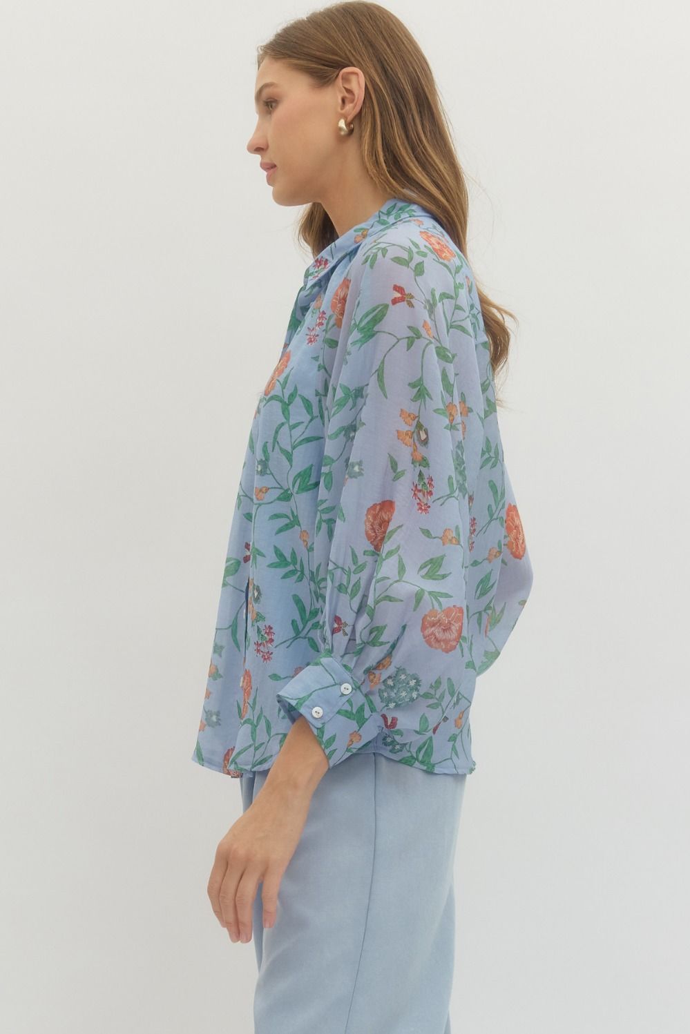 Woman wearing a floral blouse with a plain background