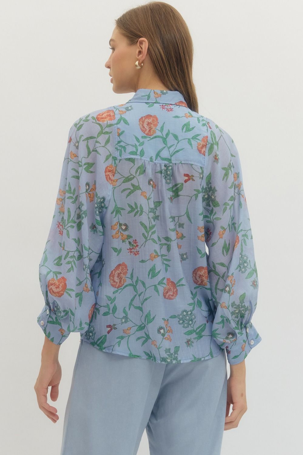 Woman wearing a floral blouse with a plain background