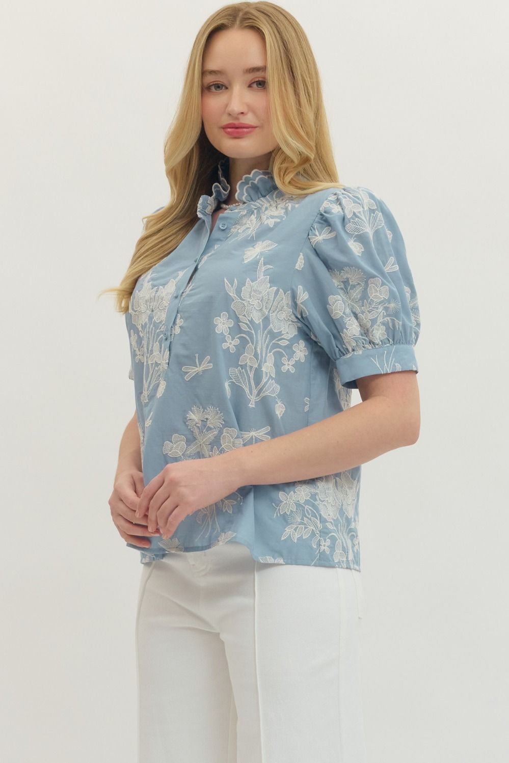 Woman wearing a blue floral blouse against a white background