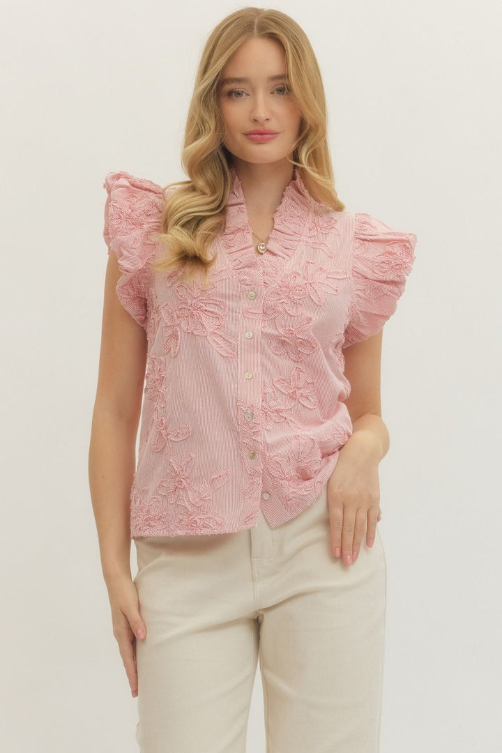 Woman wearing a pink lace top with ruffled sleeves on a white background