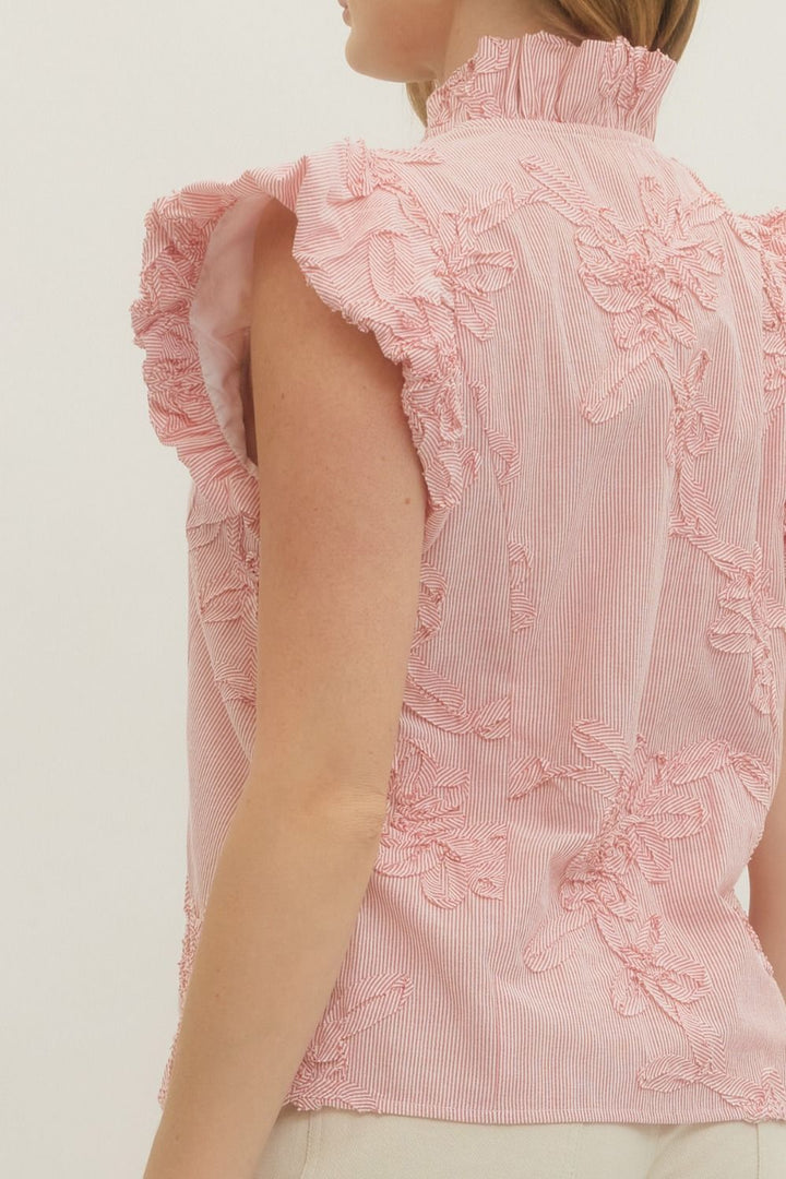 Pink floral top with ruffled sleeves on a plain background