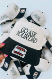 Hat with 'Go Ask Your Dad' text held by a hand against a white background