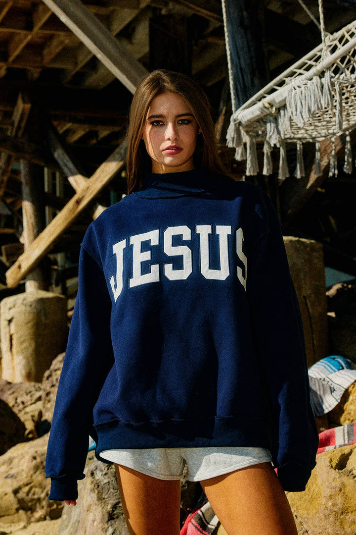 Person wearing a navy blue hoodie with &