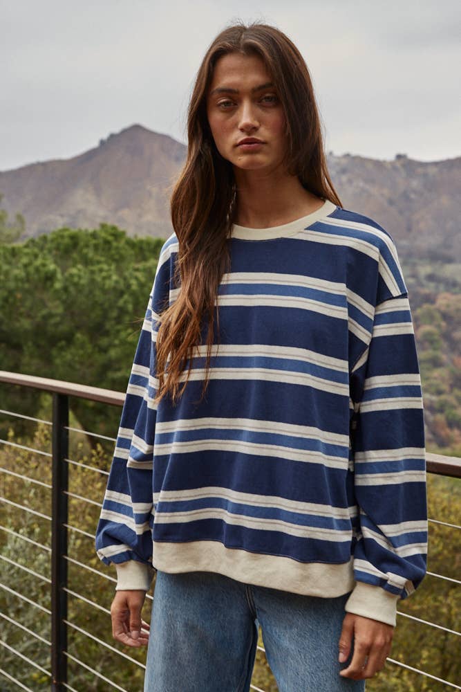 Woman wearing a blue and white striped sweater with a mountainous background